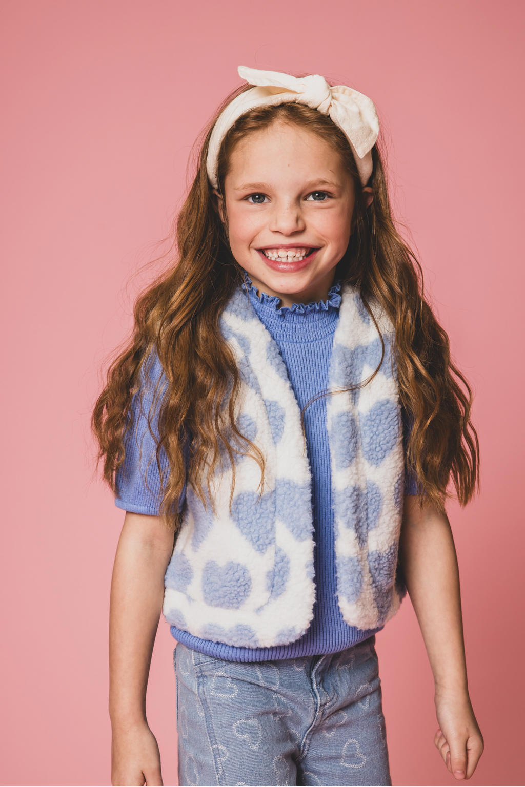 Ecru en blauwe meisjes LOOXS little gilet van teddy materiaal met hartjesprint en openvallende hals